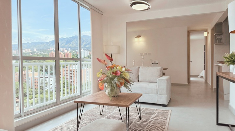 Sala comedor del apartamento modelo con ventanal y balcón